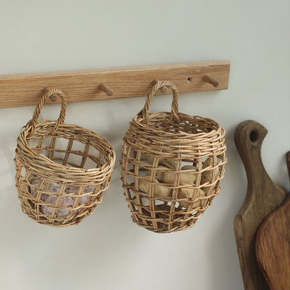 Two woven wicker baskets hanging from a wooden peg rack on a light wall, with neutral decorative items inside.