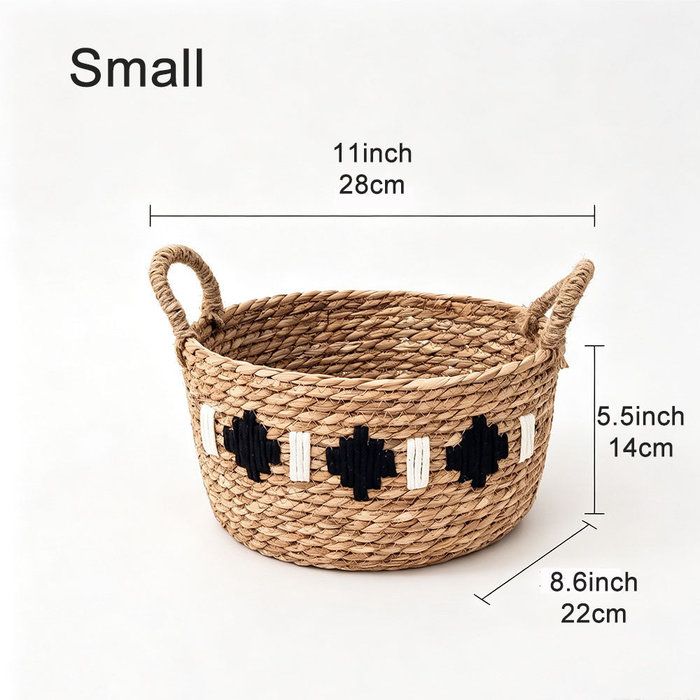 A woven natural-fiber basket with two loop handles and black-and-white geometric accents